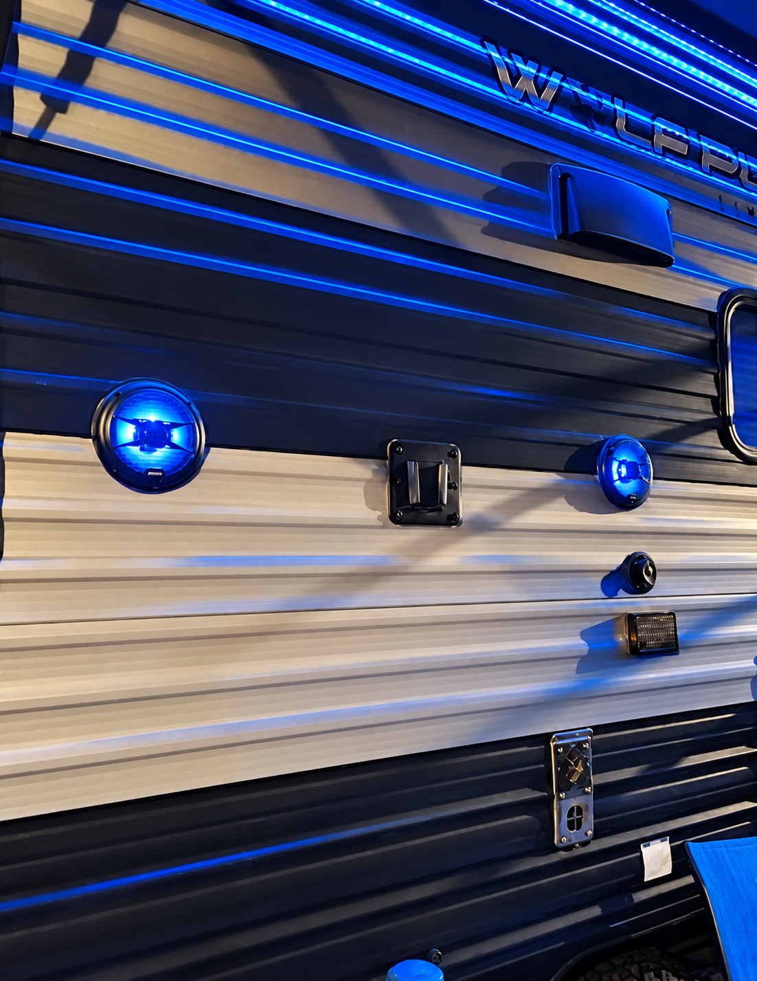 Blue-lit outdoor speakers at the So Fly setting after dark