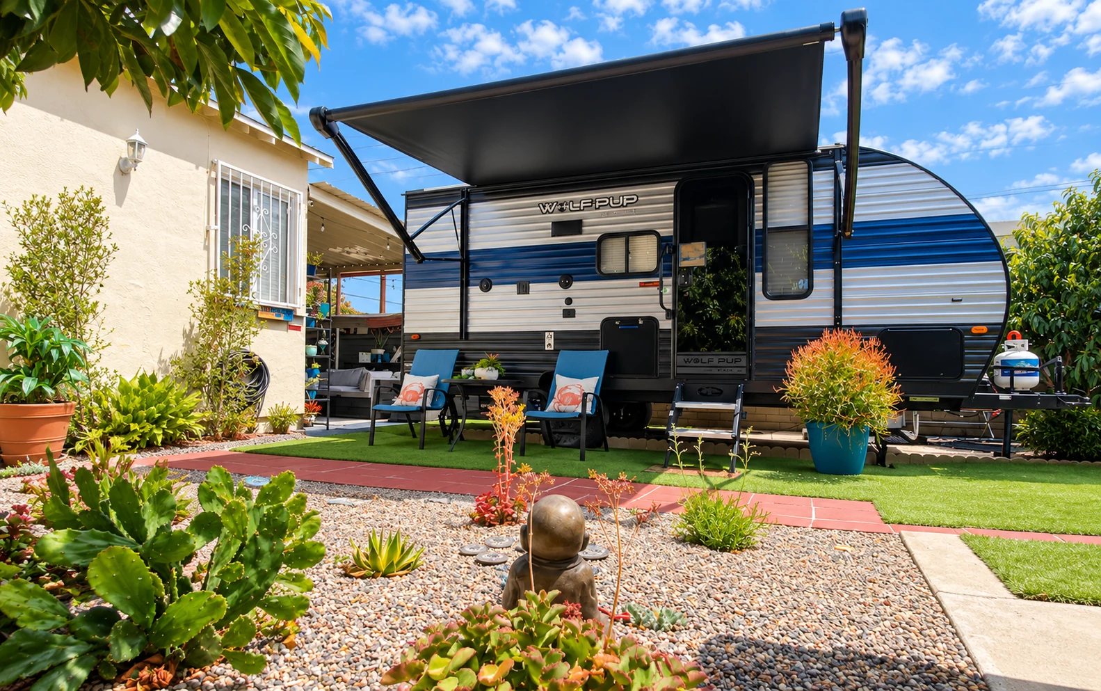 The blue and white glamper beside the patio and garden